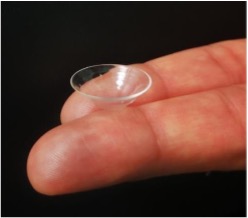 Contact lens resting on top of fingertips