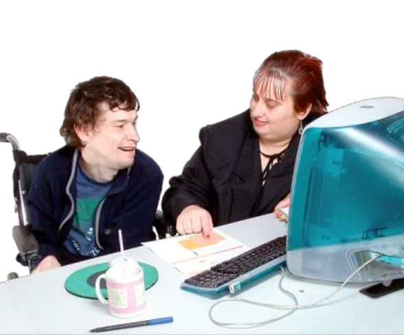 Two people sitting on a computer speaking with each other, one is seated in a wheelchair