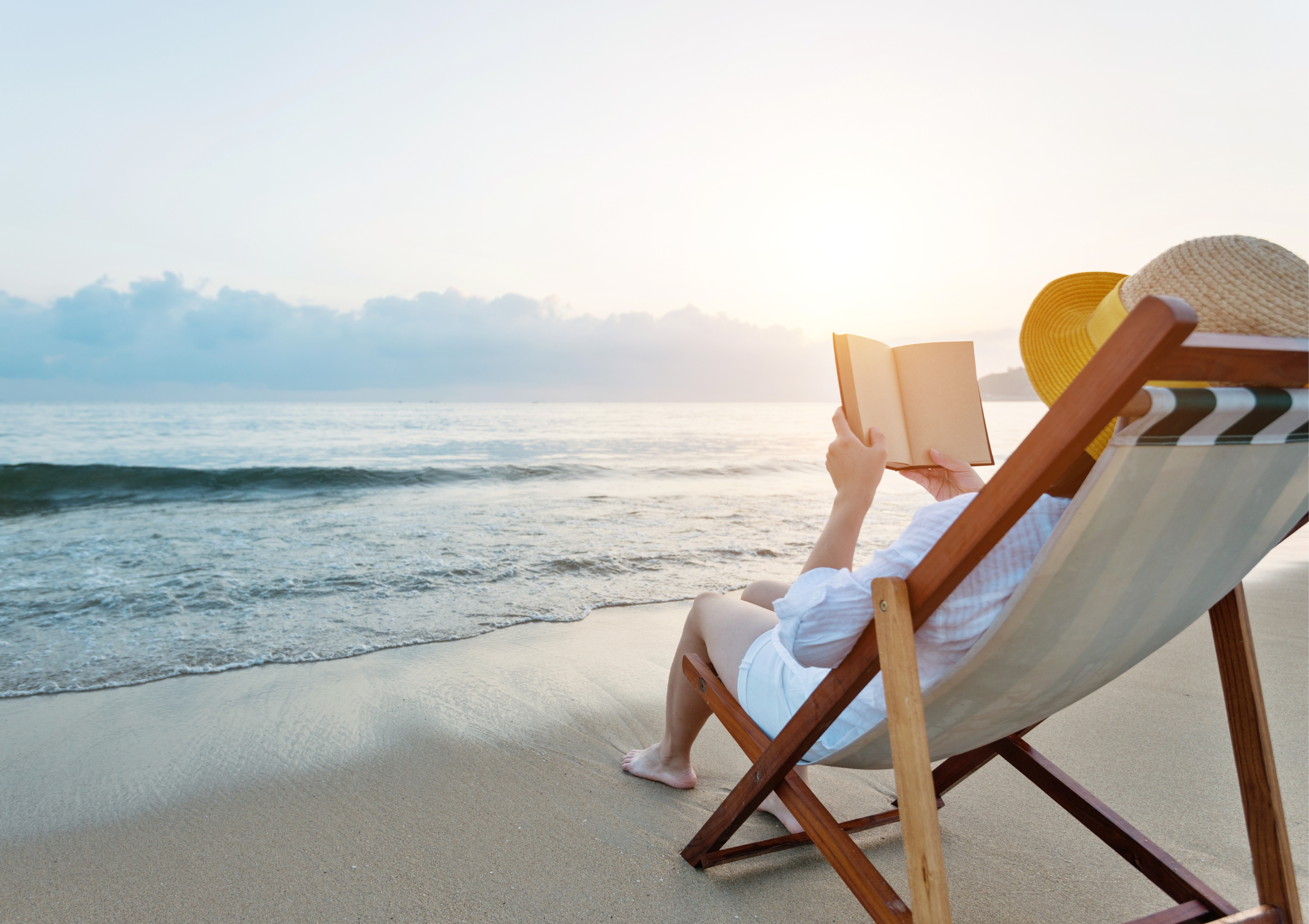 A woman reading a book by the sea
