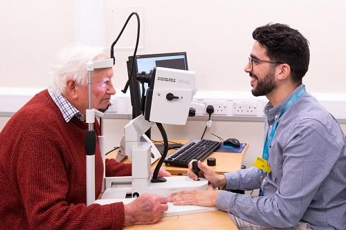 Consultant examining patient using technical equipment in a consultation room