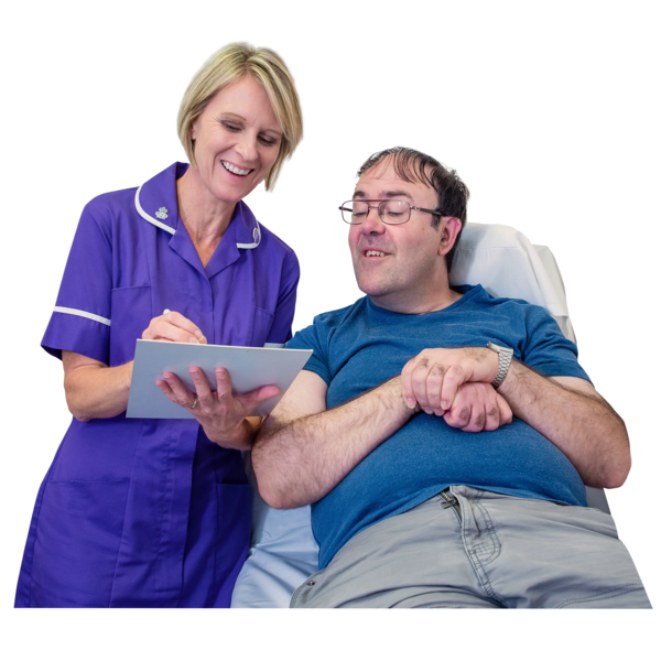 Nurse with paperwork speaking to a patient lying on a hospital bed