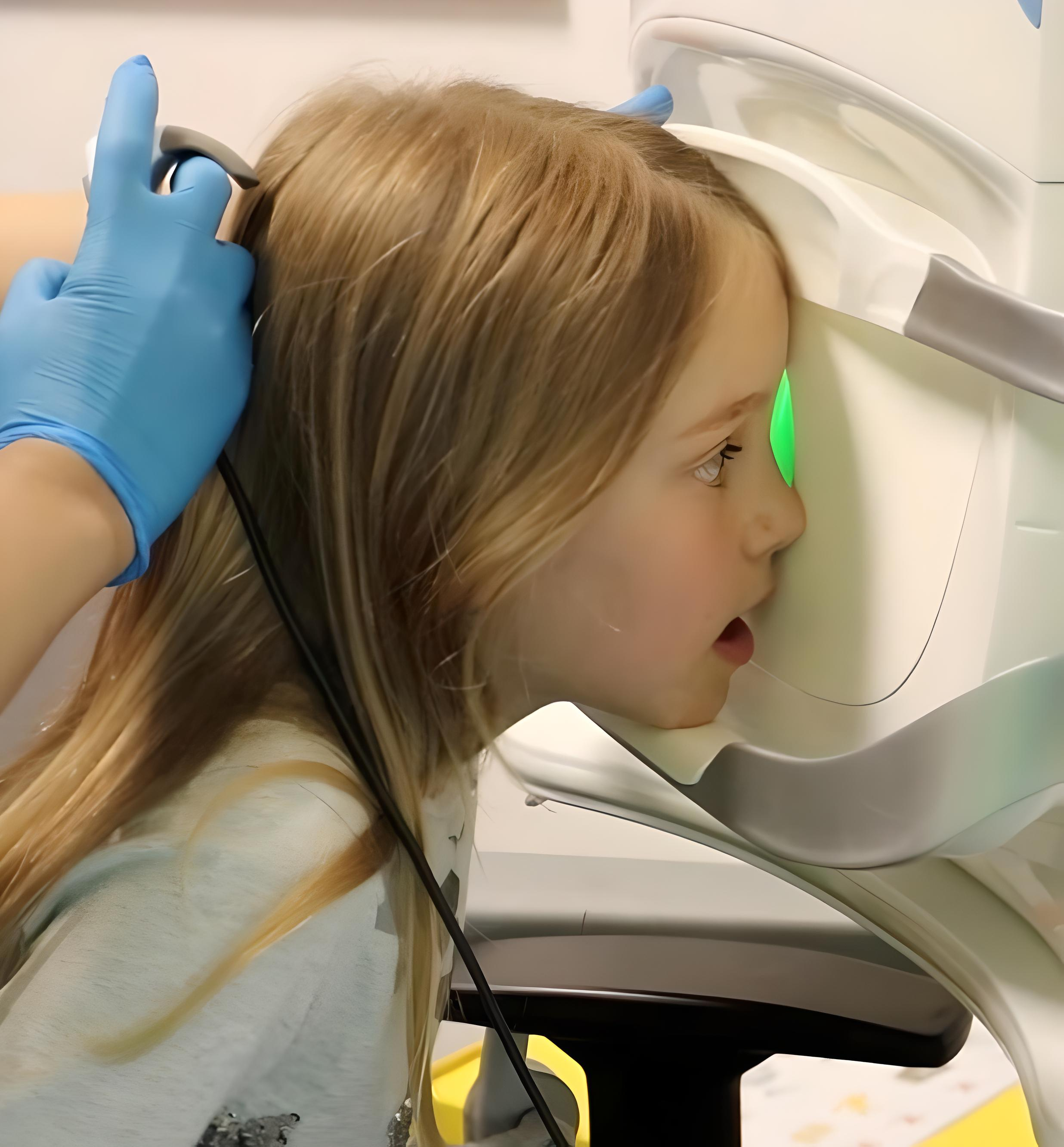 Young person looking into an eye test machine