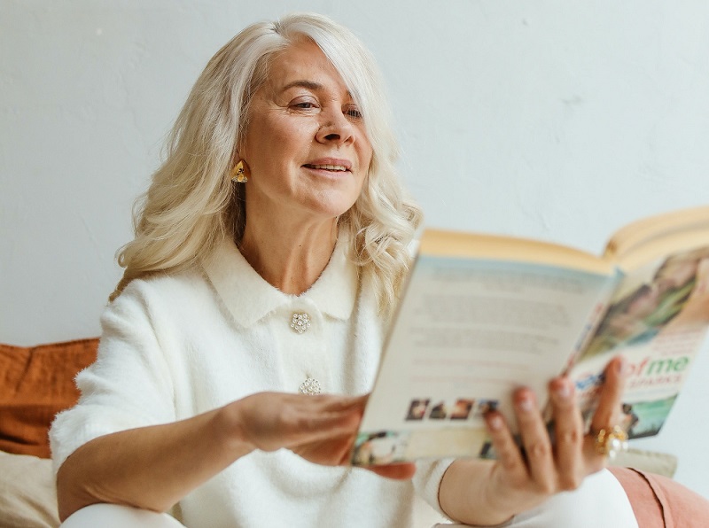 An older woman flicking through a book