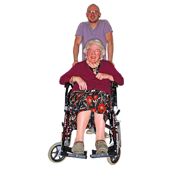 Person sitting in a wheelchair with their carer standing behind them