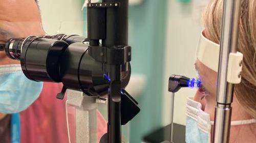 Close-up photo of a patient getting eye examination with medical equipment