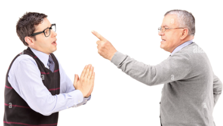 Person standing with one hand on their hip using the other to point at someone else whose hands pressed flat together